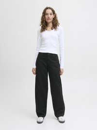 Long-sleeve white ribbed top with a V-neck, paired with wide-leg black pants and casual white sneakers with grey accents. Minimalist design.
