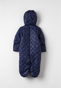 Navy blue quilted snowsuit with a hood, featuring a textured pattern, long sleeves, and footed design. Back view shows central seam.