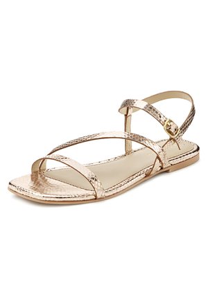 Metallisch goldene flache Sandale mit gekreuzten Riemen und verstellbarem Knöchelverschluss. Glatter Schuhboden und strukturiertes Obermaterial mit einem Reptilienhautmuster.