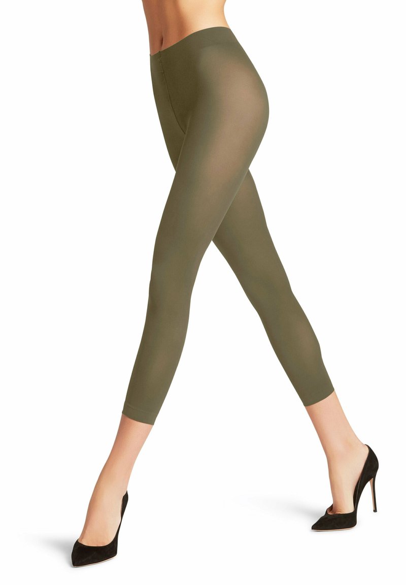 Leggings verde oliva con una superficie liscia e trasparente. Presentano un design aderente che termina poco sopra la caviglia, abbinati a tacchi alti neri.