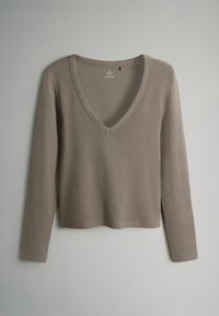 Top a maniche lunghe con scollo a V in un morbido colore taupe, realizzato in tessuto a costine con un taglio rilassato e spacchi laterali all'orlo.