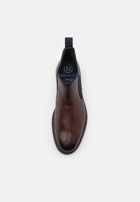 Cizmă din piele maro, până la gleznă, cu panouri elastice pe laterale, tab cu ajutor pentru încălțare, vârf rotund și cusături decorative pe talpă. Mărimea 42.