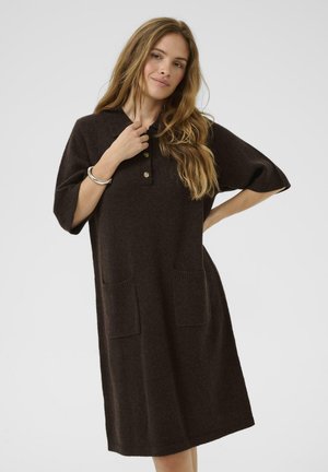 Robe marron, longueur genoux, en tissu doux. Col polo avec patte de boutonnage à trois boutons, manches courtes et deux poches avant. Détail tricoté texturé.