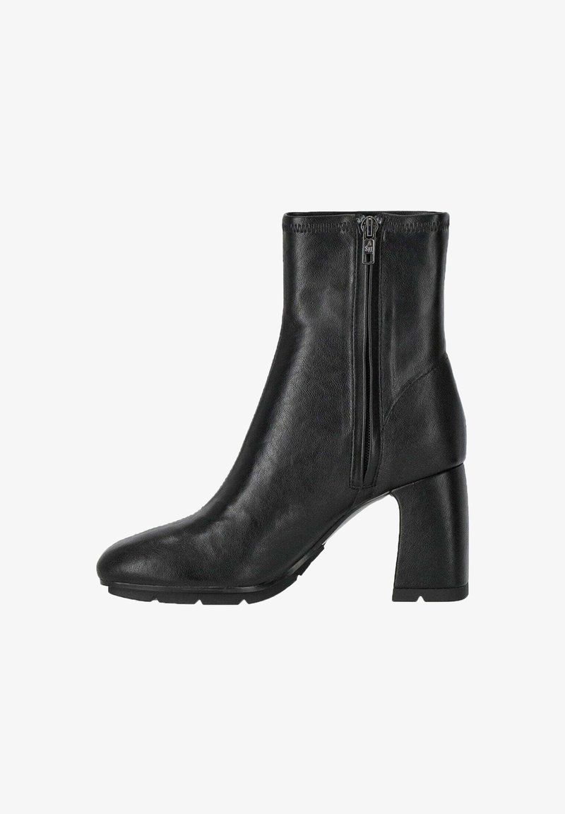 Bottine noire avec une finition en cuir brillant, à bout carré et à talon épais. Présente des zips latéraux doubles pour un enfilage et un retrait faciles.