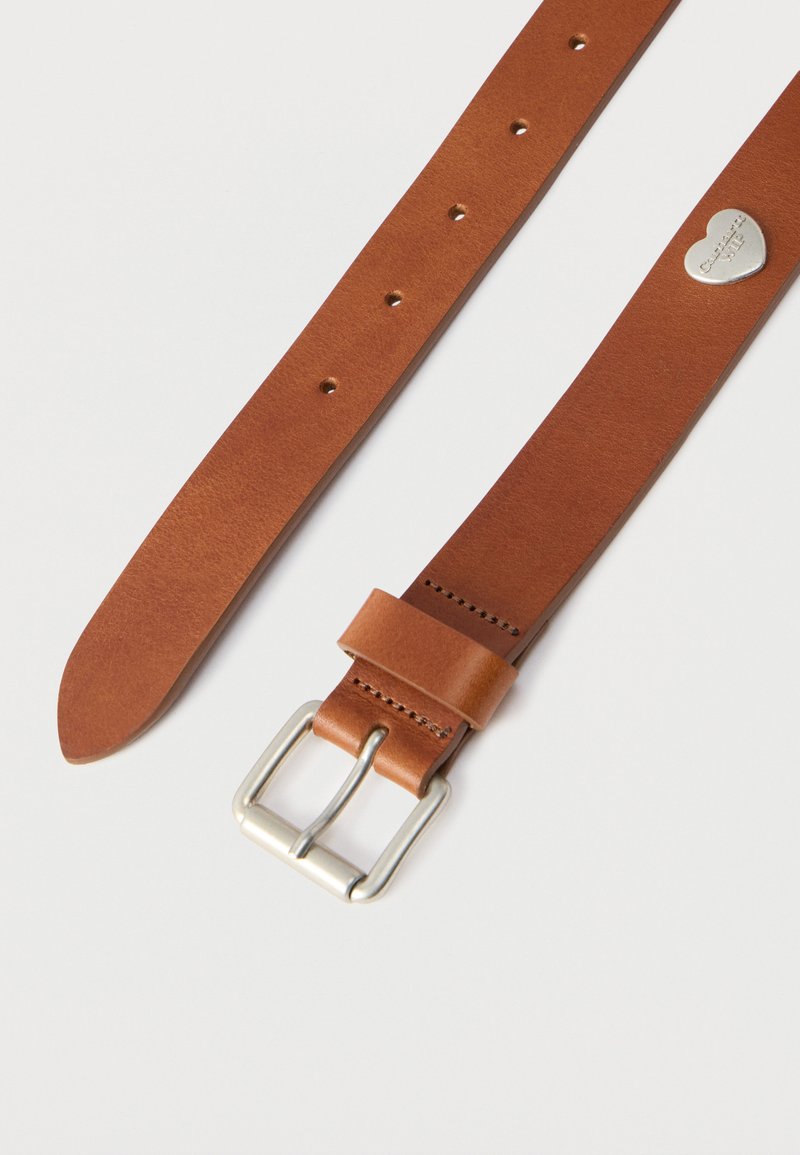 Brown leather belt with a smooth texture, silver metal buckle, five adjustment holes, and a small heart-shaped tag near the buckle.