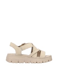 Sandale beige à talon plat avec une semelle en cuir lisse. Présente des larges brides croisées et une sangle de cheville réglable pour un soutien optimal.