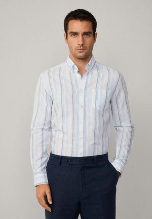 Himmelblau-weiß gestreiftes Langarmhemd mit Button-Down-Kragen, einer Brusttasche und strukturiertem Stoff, kombiniert mit navyblauen Hosen.