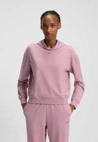 Rosa sweatshirt med kappa-hals, långa ärmar och logotypdetalj. Tyget har en slät struktur och en åtsittande silhuett, kombinerat med matchande byxor.