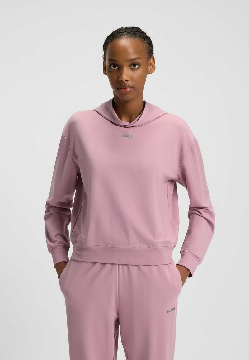 Rosa sweatshirt med kappa-hals, långa ärmar och logotypdetalj. Tyget har en slät struktur och en åtsittande silhuett, kombinerat med matchande byxor.