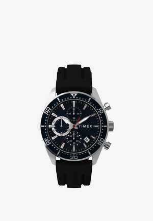 Zegarek naręczny chronograf z czarną tarczą, srebrnymi znacznikami, trzema tarczkami dodatkowych funkcji, okienkiem daty, srebrną kopertą i czarnym gumowym paskiem.