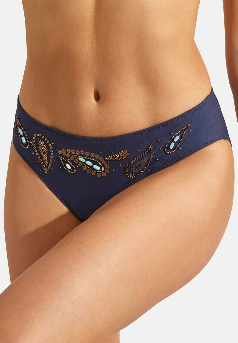 Bas de bikini bleu marine avec des broderies décoratives en or et turquoise, présentant une texture lisse et un design taille mi-haute.