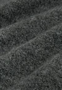 Tissu texturé gris foncé avec une surface douce et pelucheuse, présentant un motif en côtes qui crée des vagues douces et de la profondeur.