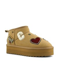 Stivaletti alla caviglia in velluto a coste color cognac con suola spessa in gomma, decorati con toppe ricamate raffiguranti una farfalla, un cuore, la lettera "C" e delle stelle.