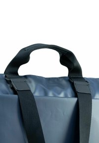 Borsa waterproof grigia con manici neri, caratterizzata da una texture liscia e un'apertura pieghevole nella parte superiore. Ampio manico per una facile portabilità. Design minimalista.