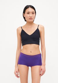 Svart bomull-bralette med tynne stropper, sammen med lilla bomullsbokser med bred midje. Glatt tekstur, tettsittende design.