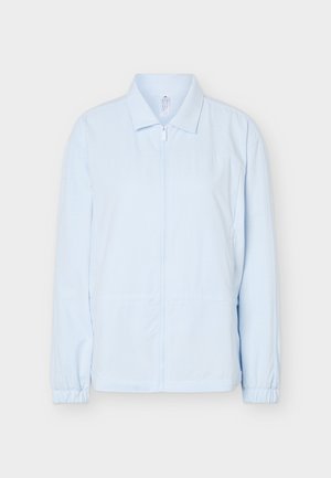 Veste bleu clair à manches longues avec fermeture éclair frontale, col pointu et poignets élastiques, présentée sur un fond uni.