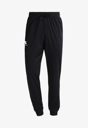Pantalones de chándal negros confeccionados en una mezcla de algodón; cinturilla elástica con cordón, pierna ajustada y logo blanco en el muslo izquierdo. Textura suave.