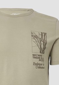 Olijfgroene katoenen T-shirt met een gedrukte afbeelding van boomtakken en tekst. Ronde hals met korte mouwen en een gladde textuur.