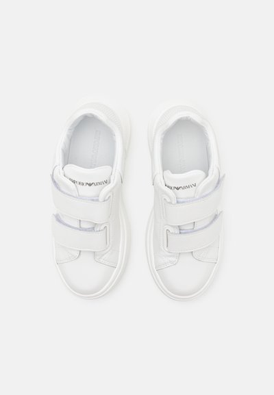 Hvite sneakers med en glatt læroverflate, rund tå og to justerbare borrelåsremmer for en sikker passform.