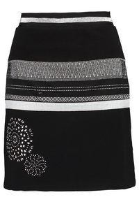 Svart kjol med dekorativa silverhorisontella mönster och utskurna detaljer vid fållen. Tillverkad av mjukt tyg med en figurnära passform.