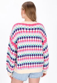 Pulover croșetat cu model de diamante multicolore în nuanțe de roz, violet, albastru și crem. Croială lejeră, guler și manșete cu nervuri.