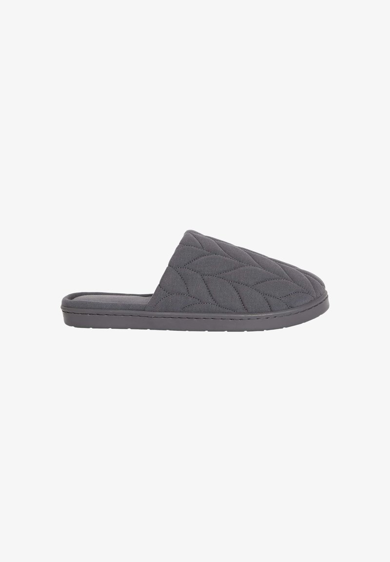 Pantofole grigie trapuntate con una texture morbida, apertura sul retro e suola piatta in gomma. Presentano un motivo a foglia cucito sulla parte superiore.