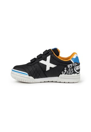 Zapatillas de tela negras con un diseño de X en blanco, correas de gancho y bucle, acentos naranjas, patrones gráficos en el talón y una suela de goma texturizada.
