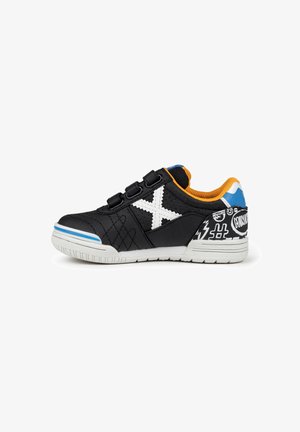 Zapatillas de tela negras con un diseño de X en blanco, correas de gancho y bucle, acentos naranjas, patrones gráficos en el talón y una suela de goma texturizada.