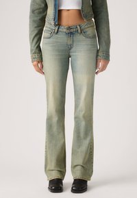 Ανοιχτό μπλε τζιν με κλος, με διακριτικό διαβαθμισμένο ξέβγαλμα, πέντε τσέπες και αντίθετο ράψιμο. Συνδυασμένο με μαύρα μποτάκια για αντίθεση.