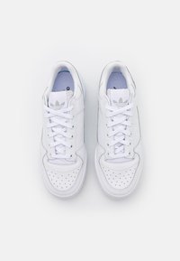 Vita lädersneakers med perforerat tåparti, snörning och blå innerfoder. Har tre-stripes-logotyp på tungan och en slät yta.