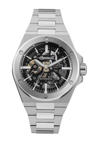 Automatisch horloge met een zilveren roestvrijstalen kast en armband, zwarte skeleton wijzerplaat, zichtbare beweging en zilverkleurige accenten.