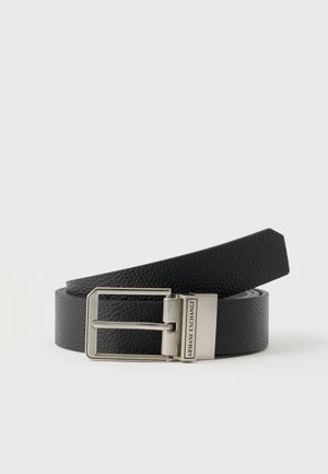 Ceinture en cuir noir texturé avec une boucle rectangulaire argentée et le logo Armani Exchange sur le fermoir métallique, posée sur un fond clair.