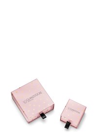 Rosa presentförpackningar med guldfärgade hjärt-mönster, som innehåller en större låda och en mindre låda, båda med svarta snördrag.