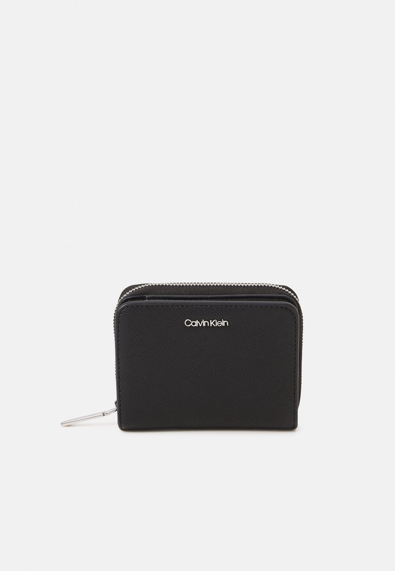 Calvin Klein black wallet in textured fabric, featuring a zip closure and silver-tone logo. Compact rectangular shape with a sleek design.