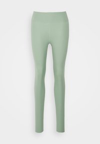Leggings di un verde chiaro, realizzati in tessuto elasticizzato con una superficie liscia. Presentano un'alta vita e un design aderente senza fantasie.