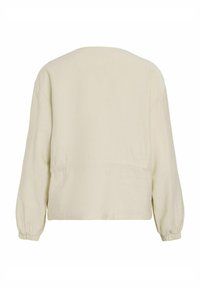 Krémová skrátená bunda s dlhými balónovými rukávmi, z jemného materiálu a s gumičkami na zápästiach. Jednoduchý, minimalistický dizajn bez viditeľného zapínania.