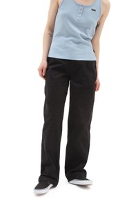 Top de tirantes azul claro, acanalado, con detalle de botones, combinado con pantalones negros de corte holgado y zapatos de slip-on negros con acentos blancos.