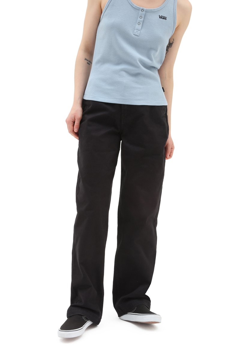 Top de tirantes azul claro, acanalado, con detalle de botones, combinado con pantalones negros de corte holgado y zapatos de slip-on negros con acentos blancos.