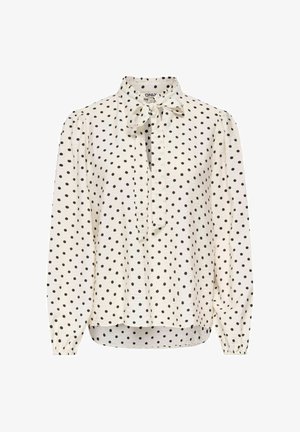 Blouse blanche à manches longues à pois noirs, patte de boutonnage devant, poignets élastiques et col avec un nœud.