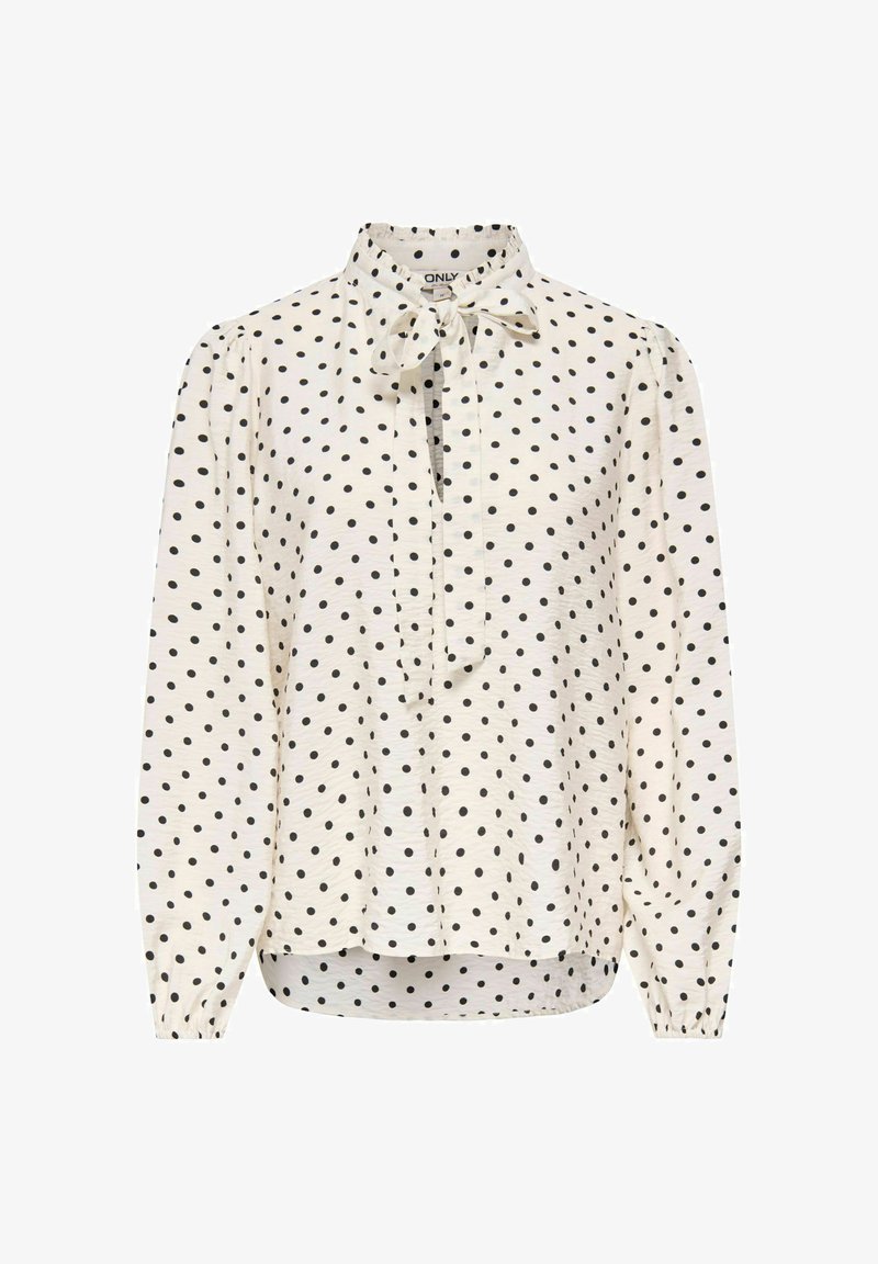 Blouse blanche à manches longues à pois noirs, patte de boutonnage devant, poignets élastiques et col avec un nœud.