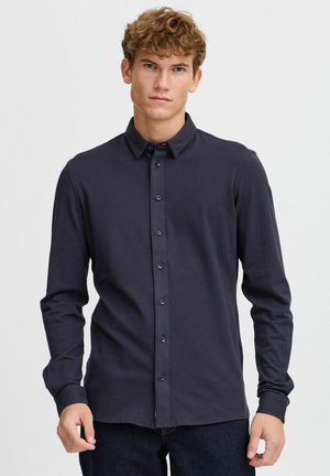 Navy long-sleeve button-up shirt in a smooth fabric, featuring a classic collar and matching buttons, with a regular fit and straight hem.