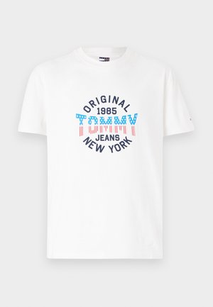 White cotton t-shirt with short sleeves featuring multicolored graphic print: "ORIGINAL 1985 TOMMY JEANS NEW YORK" with red stripes and blue accents.