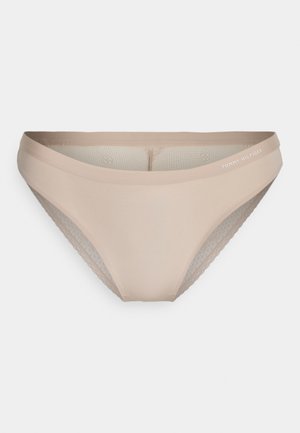 Beige underwear with a smooth front panel, mesh side accents, and a logo on the waistband. Features a low-rise design and soft texture.