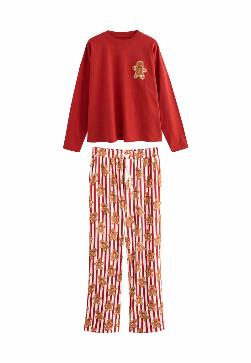 Maglietta rossa a maniche lunghe con un'applicazione di un omino di pan di zenzero, abbinata a pantaloni bianchi con righe rosse e molteplici stampe di omino di pan di zenzero.