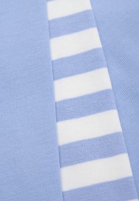 Ljusblå plagg med ribbad textur, featuring en vit och ljusblå randig accentpanel på en sida.