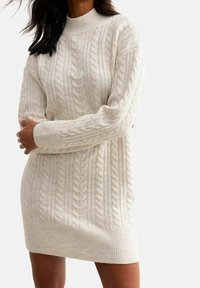 Robe pull tricotée de couleur crème, dotée de motifs en câble, d'un col montant, de poignets côtelés et d'une coupe décontractée, idéale pour superposer.