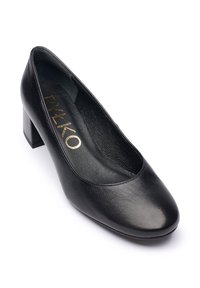 Zwarte leren pump met een ronde neus, lage blokhak en een gladde textuur. Binnenin zit een gevoerde binnenzool met zichtbaar merklogo.