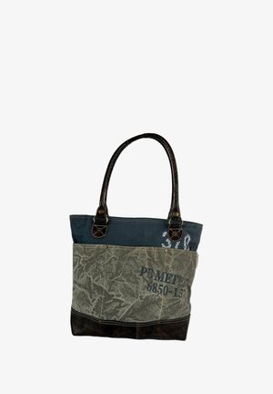 Canvas tas met donkerbruine leren handvatten. Heeft een blauwe bovenkant, een groene onderkant met een patroon en tekstdetails in het zwart.