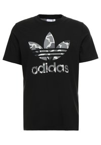 Černé bavlněné tričko s velkým šedým logo Adidas se vzorem kamufláže a třemi vodorovnými pruhy na hrudi. Krátké rukávy, kulatý výstřih.