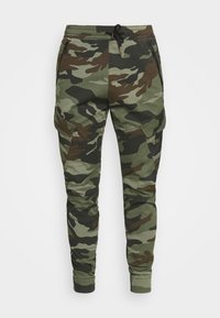 Vihreät, ruskeat ja beiget maastokuvioiset collegehousut. Joustava vyötärönauha kiristysnauhalla, kapeat lahkeet ja useita sivutaskuja. Kestävä kangas, rento malli.